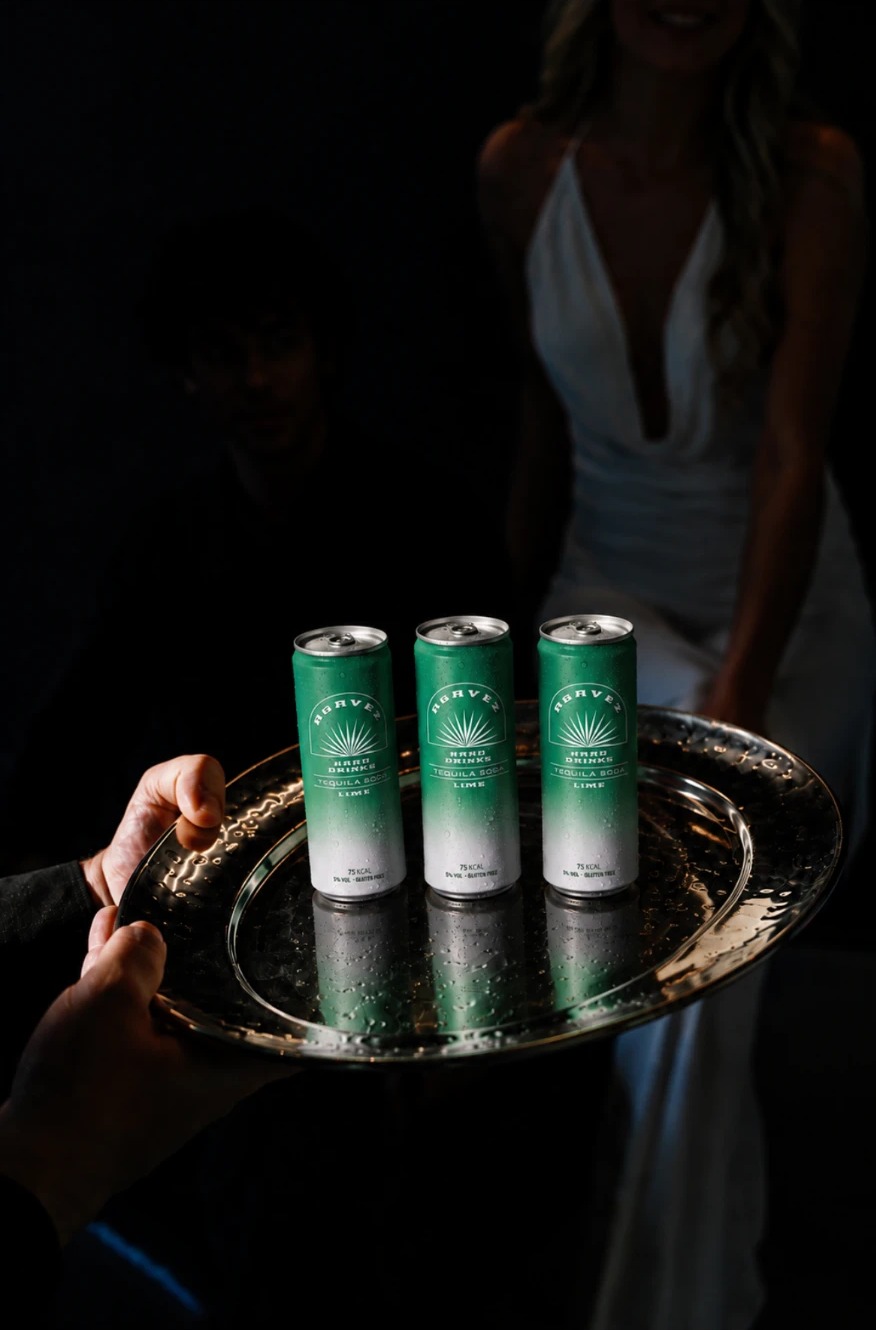Three Agavez Tequila Soda Lime cans served chilled on a silver tray in low light